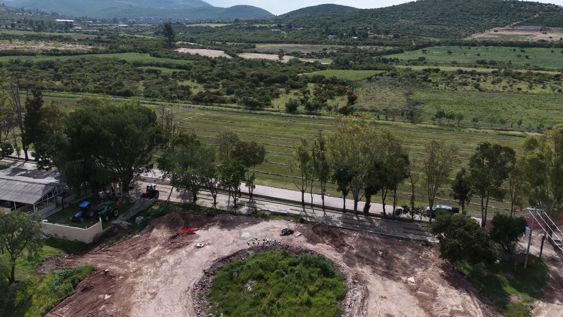 Hilera de árboles junto al terreno y el valle al fondo